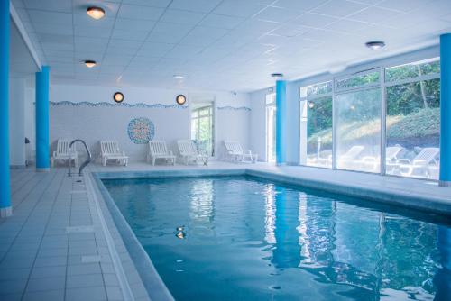 a swimming pool in a house with blue columns at Residence Le Royal Golf & Horse in Mooslargue