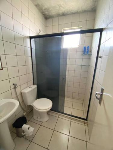 uma casa de banho com um chuveiro, um WC e um lavatório. em Apt confortável perto do centro em Palmas