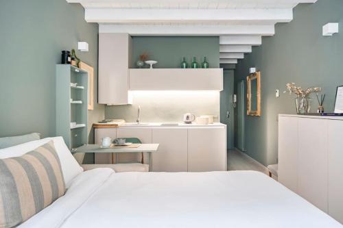 1 dormitorio con 1 cama blanca y cocina en Bergamo Center [SUITE MIA] - Modern & Green + WiFi, en Bérgamo