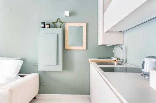 una cocina con armarios blancos y fregadero en Bergamo Center [SUITE MIA] - Modern & Green + WiFi, en Bérgamo