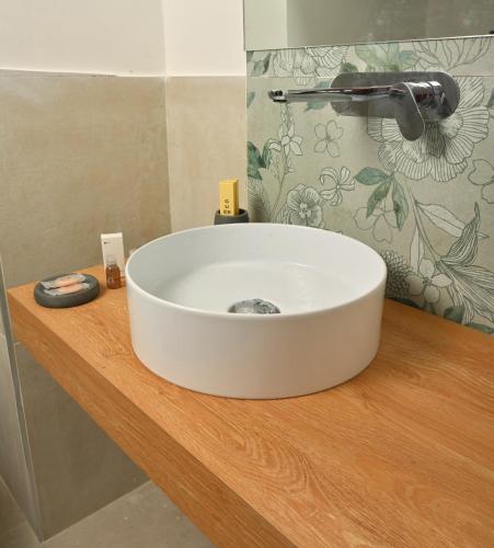 a white sink on a wooden counter in a bathroom at Ghe kalè Resort in San Paolo Bel Sito