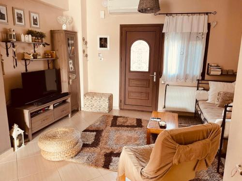 sala de estar con sofá y TV en Stelina, en Kavala