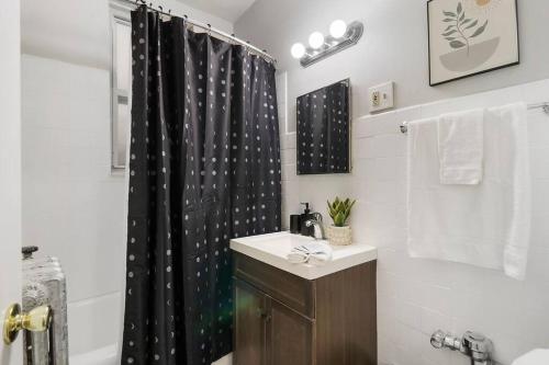 a bathroom with a black shower curtain and a sink at Trendy Studio Apartment in Chicago - Kenwood 103 & 303 rep in Chicago