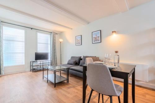 un salon avec une table et un canapé dans l'établissement Vieux-Lille/hypercentre: Lovely equipped studio, à Lille