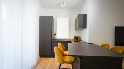a kitchen with a black table and yellow chairs at Palazzo Gilberto in Padova
