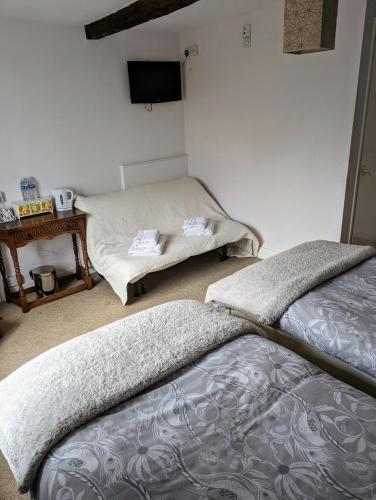 a bedroom with two beds and a tv on the wall at Bartholomew Arms in Northampton