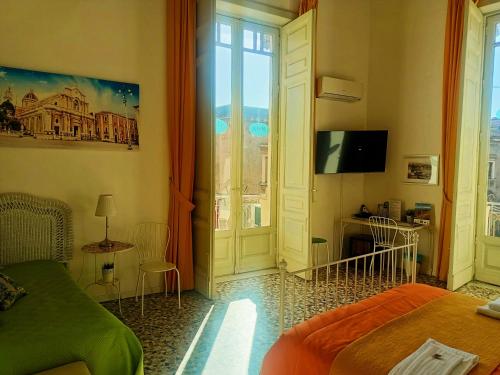 een slaapkamer met een bed, een tv en een raam bij B&B Perla in Catania