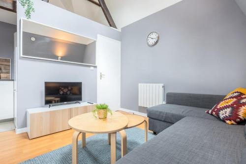 un salon avec un canapé et une table dans l'établissement Lille proche Wazemmes/Jb Lebas - 2 bed apartment, à Lille