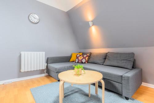 un salon avec un canapé gris et une table dans l'établissement Lille proche Wazemmes/Jb Lebas - 2 bed apartment, à Lille