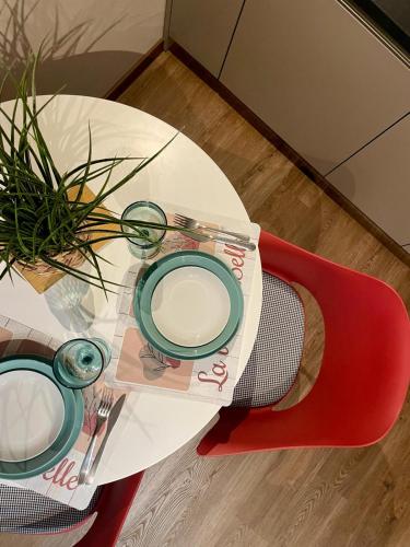 a white table with a plate and a red chair at Bnbook Expo Residence Rho in Rho