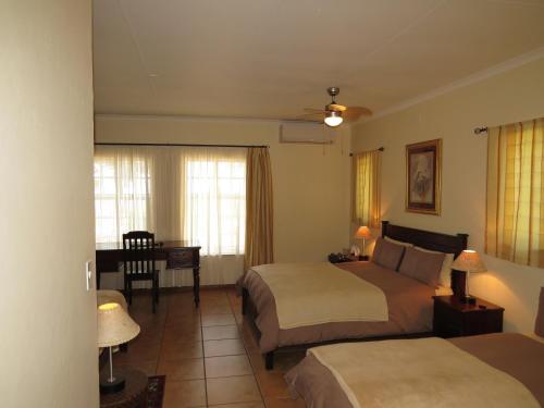a hotel room with two beds and a desk at White House Lodge in White River