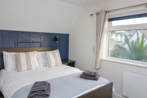 a bedroom with a large bed with a window at 8 Little Hill in Salcombe