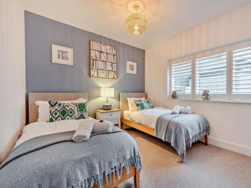a bedroom with two beds and a window at 4 Bed in Appledore 92017 in Appledore