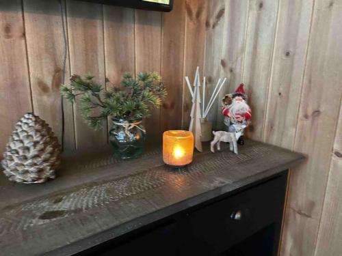 a counter with a candle and a vase with christmas decorations at Cosy cabin between lake and mountain in Treungen