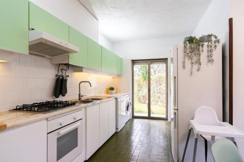 a kitchen with green cabinets and white appliances at Garden House in Cascais