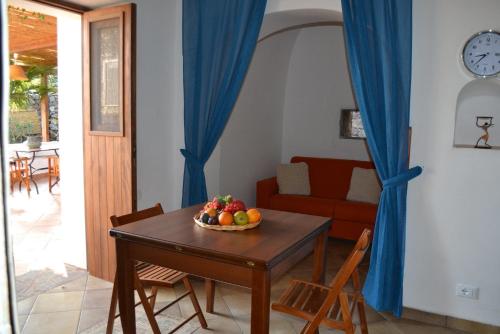 uma sala de estar com uma mesa com uma taça de fruta em Dammuso Primavera em Pantelleria