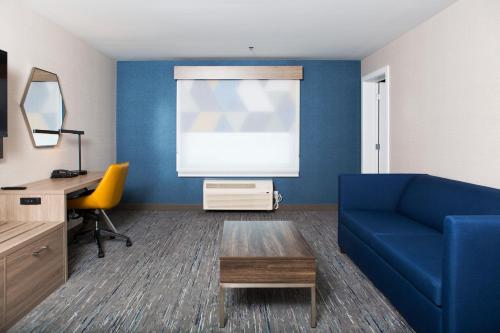a living room with a blue couch and a desk at Holiday Inn Express & Suites Prince Albert - South by IHG in Prince Albert