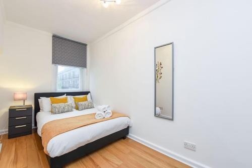 a bedroom with a bed and a mirror on the wall at Central London- 1 Bed Apartment! in London