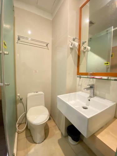 a bathroom with a white sink and a toilet at Kimono Spa Hotel in Kuta