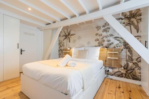 - une chambre avec un lit blanc et un papier peint tropical dans l'établissement Lille Beaux Arts equipped apartment, à Lille