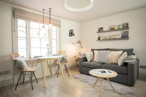 a living room with a couch and a table at Artizan's Nest - central, Scandi style in Bath