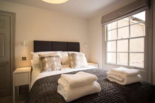 a bedroom with a bed with towels on it at Artizan's Nest - central, Scandi style in Bath