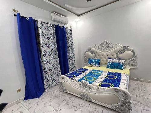 a bedroom with a bed with blue and white curtains at Résidence meublée in Ouagadougou