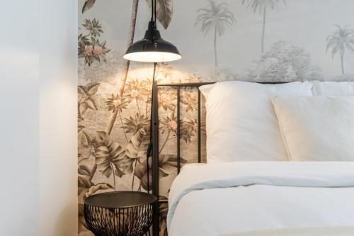 - une chambre avec un lit et un mur orné de palmiers dans l'établissement Hypercentre Beaux-Arts charming studio Lille, à Lille