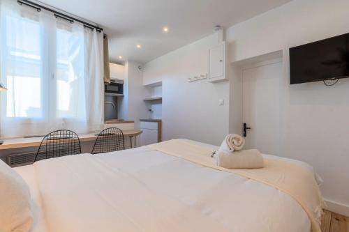 - une chambre avec un lit blanc et une serviette dans l'établissement Hypercentre Beaux-Arts charming studio Lille, à Lille