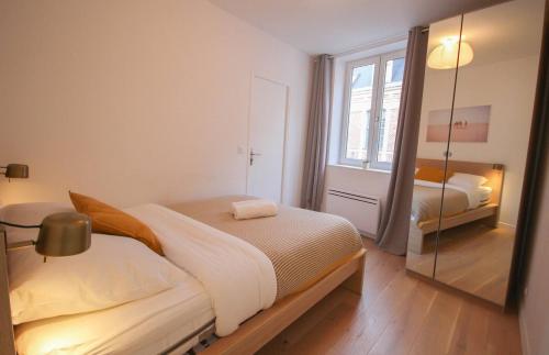 a small bedroom with a bed and a mirror at Equipped apartment premium location in Lille