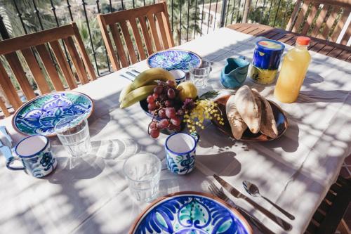 a table with plates of food and fruit on it at Casa La Martina Frigiliana in Frigiliana