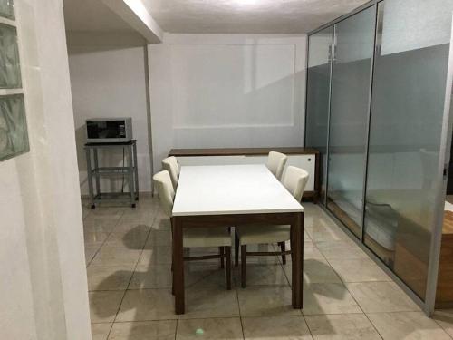 a room with a white table and chairs and a glass wall at Suite #1B Cerca de autopista Mex-Qro. in Cuautitlán Izcalli