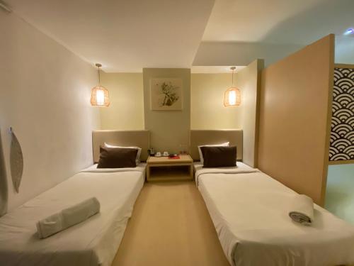 una camera con due letti e un tavolo di Kimono Spa Hotel a Kuta