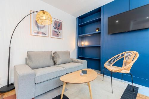 ein Wohnzimmer mit einem Sofa und einem Tisch in der Unterkunft Bright 3-bedroom 2-bathroom flat in Lille