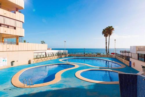 a large swimming pool with the ocean in the background at Apartamento Topacio 2 - PlusHolidays in Calpe