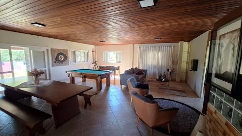 a living room with a ping pong table at Ampla casa de sítio com lagoa. in Jaguaruna