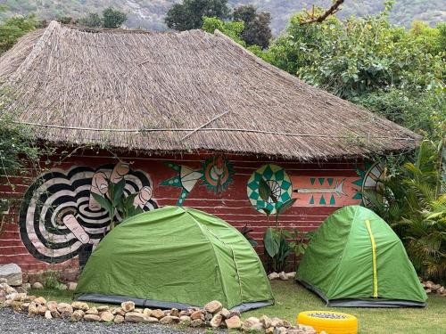 dwa zielone namioty przed budynkiem w obiekcie Namaste India w mieście Pushkar