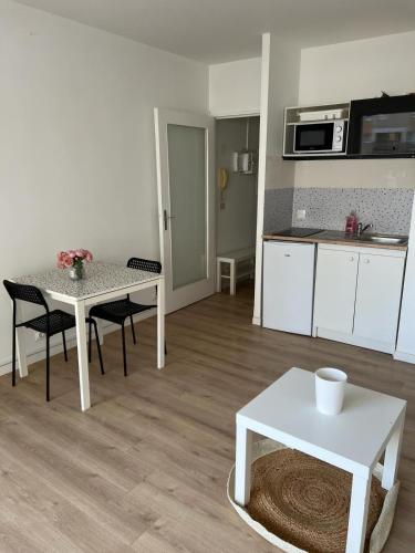 uma sala de estar com uma mesa e uma cozinha em Le Central - Studio avec terrasse Camas,Timone em Marselha