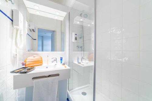 a white bathroom with a sink and a shower at Résidence Montempô Part Dieu in Lyon
