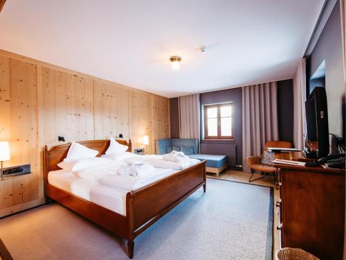 ein Hotelzimmer mit einem Bett und einem TV in der Unterkunft Alpina Lech - natural living in Lech am Arlberg