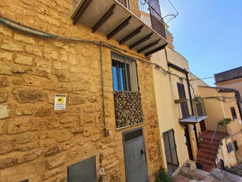 a stone building with a window and a balcony at A due passi dal centro Sweet Rooms in Agrigento