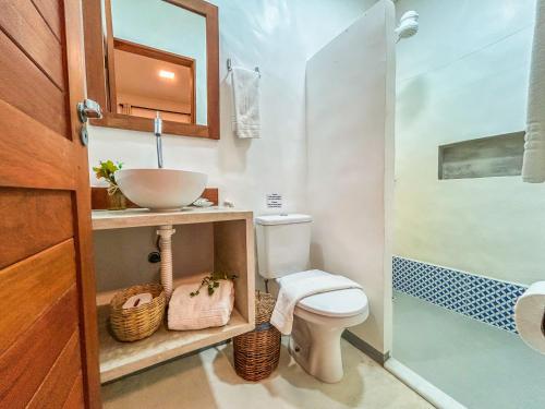 e bagno con servizi igienici, lavandino e doccia. di Maruê Guesthouse Porto de Pedras a Pôrto de Pedras