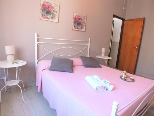 een slaapkamer met een roze bed en handdoeken bij al Nero D'Avola in Avola