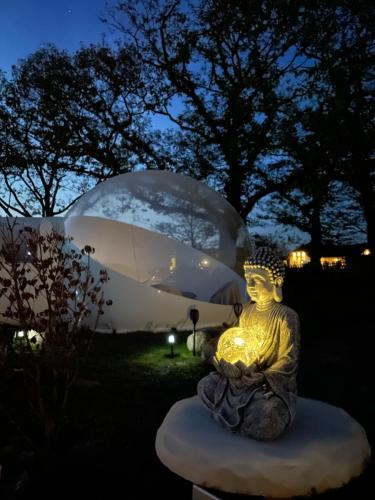 een beeld van een Boeddha voor een glazen koepel bij Bubble Tent Berlin in Altlandsberg