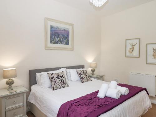 a bedroom with a bed with two white towels on it at Hazelnut Lodge in Crediton