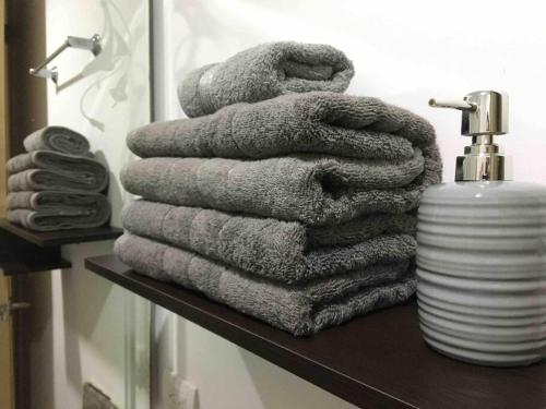 a stack of towels on a shelf in a bathroom at Estudio confortable especial para viajeros Wifi Tv Streaming in Bucaramanga