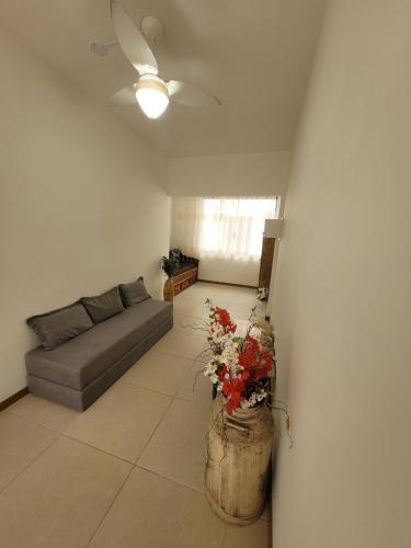 uma sala de estar com um sofá e um vaso de flores em Apartamento no Coração da Cidade! no Rio de Janeiro