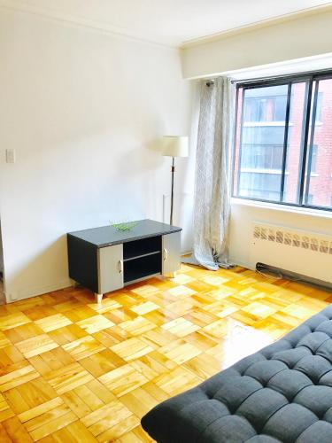 - un salon doté de parquet et d'un canapé dans l'établissement Stylish Montreal Apartment: Comfortable Stay in the Golden Square Mile, à Montréal