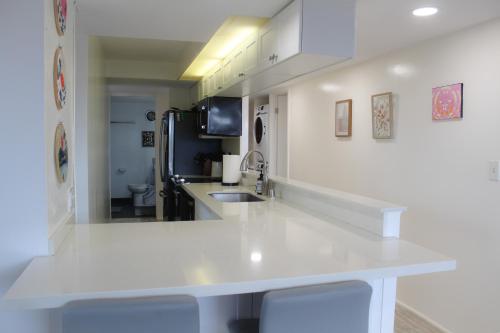 a kitchen with a white counter and a sink at Modern Futuristic Hawaii Fortress condo in Honolulu