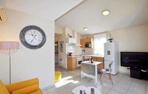 d'une cuisine et d'un salon avec une horloge murale. dans l'établissement Nice Apartment In Saleilles With Wifi, à Saleilles